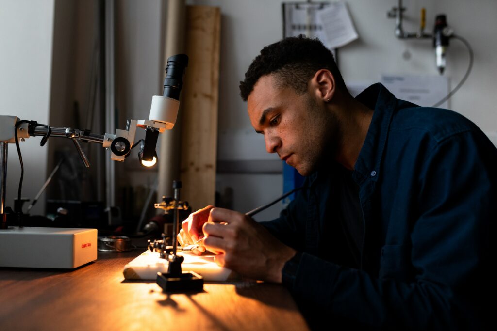 étudiant en formation d'ingénieur à Nantes qui regarde au microscope avec lumière 